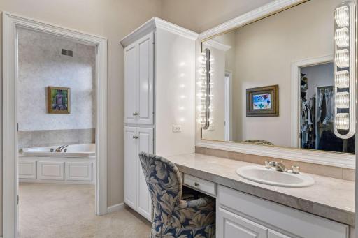 Primary bathroom vanity area offers generous storage, built-in makeup vanity and extensive counter space.