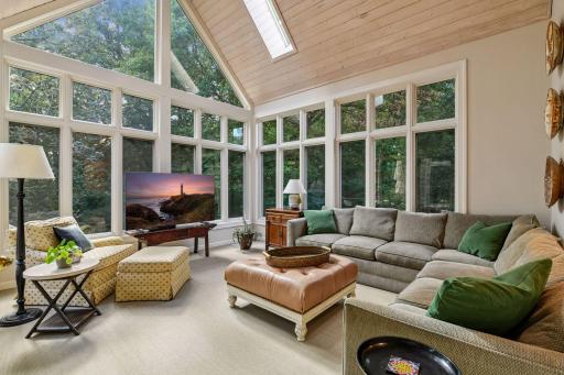 Four-season sunroom surrounded by windows with vaulted wood ceiling and peaceful views of the private backyard.