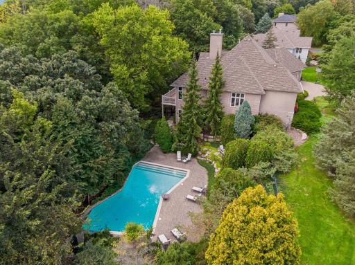 Private, custom landscaped backyard surrounded by mature trees and lush greenery.
