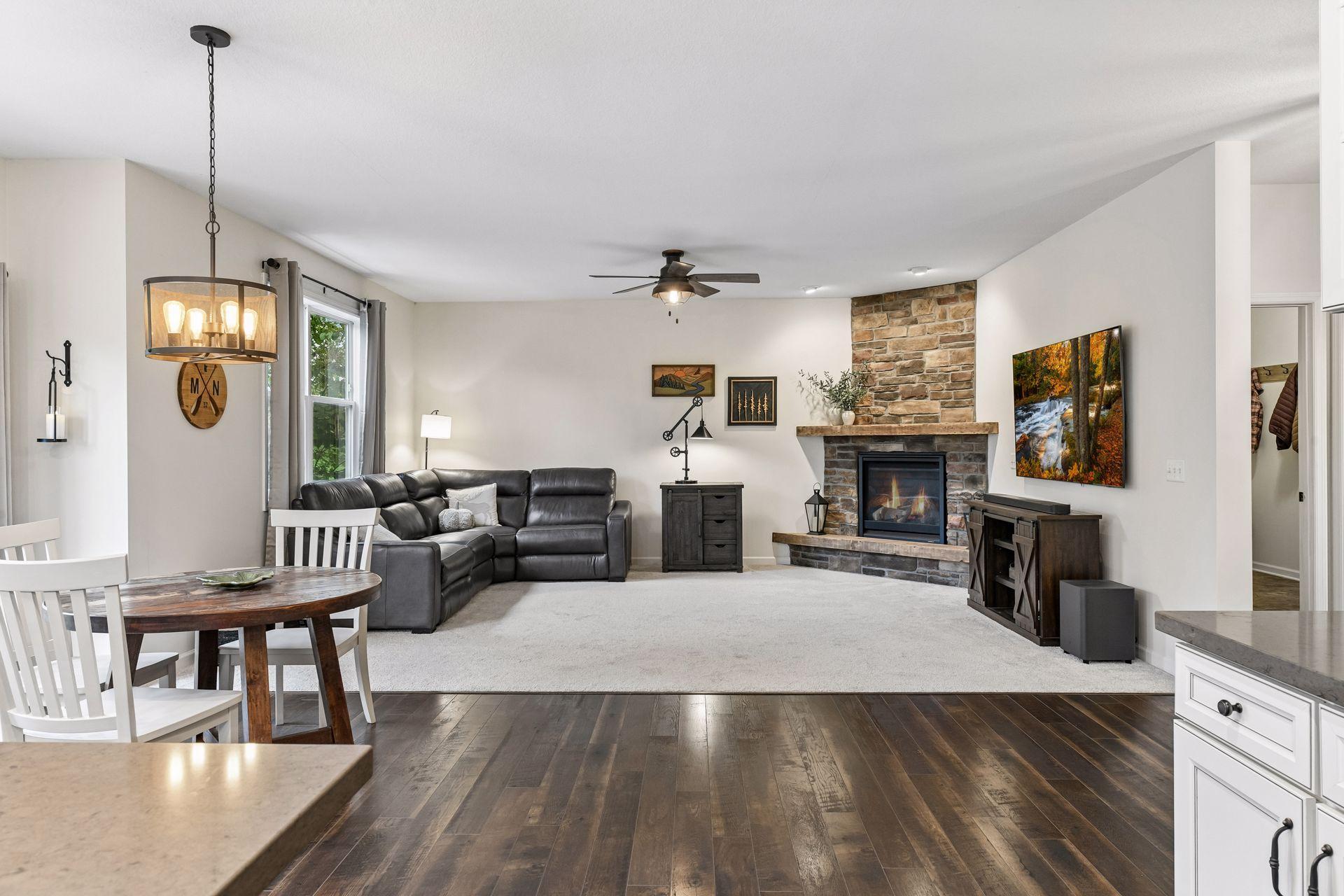 Inviting family room features a stunning floor-to-ceiling stone fireplace. The perfect space to relax, gather, and entertain year-round.