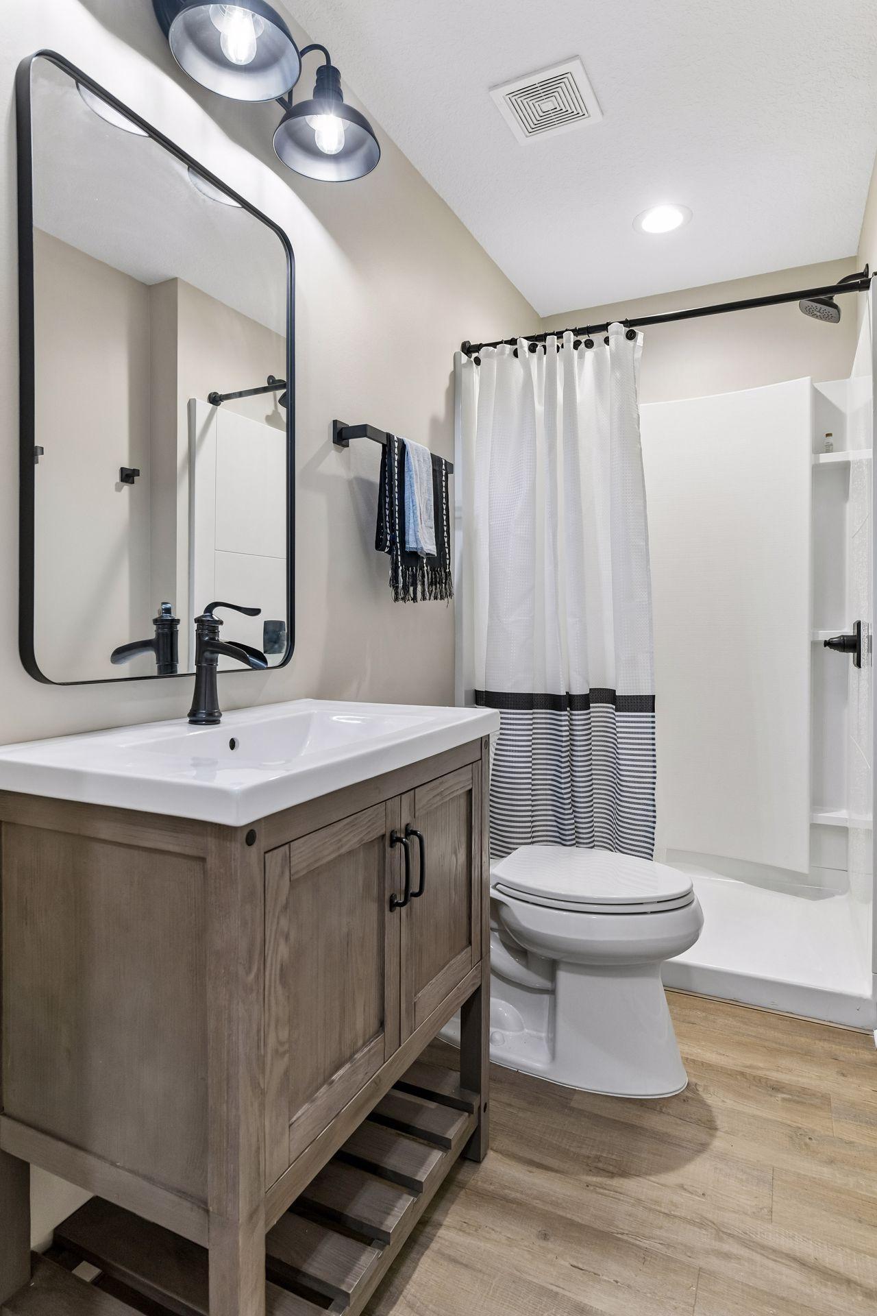 Stylish lower-level bath features a modern vanity, updated fixtures, and a convenient walk-in shower. Perfect for guests and everyday use, this thoughtfully finished space adds comfort and functionality to the lower-level living area.