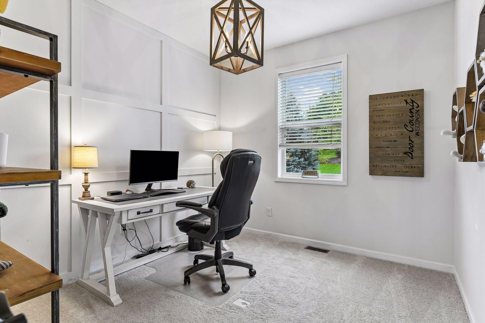 Main-level office just off the kitchen offers the perfect work-from-home setup. Bright and inviting with stylish wall detailing, a large window, and flexible space ideal for a home office, study, or hobby room.