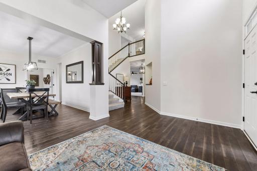 Grand two-story foyer and open-concept design welcome you home! Rich flooring, soaring ceilings, and elegant architectural details create a bright, inviting space that flows seamlessly into the dining and living areas.