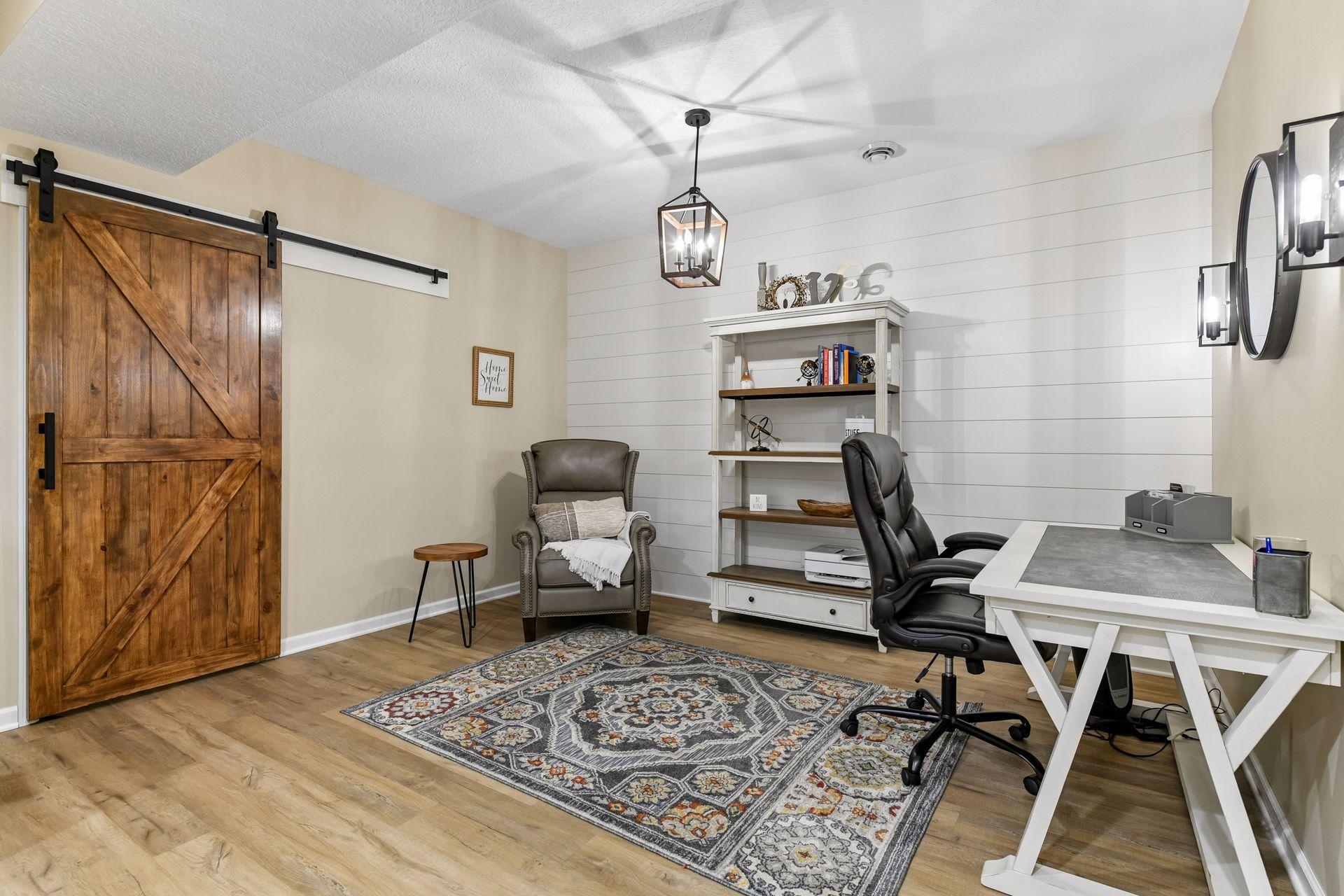 Finished lower level offers exceptional flexibility with a stylish 2nd office, study, or hobby space featuring updated flooring, shiplap accent wall, and rustic barn door. A perfect retreat for working from home, projects, or additional living space.