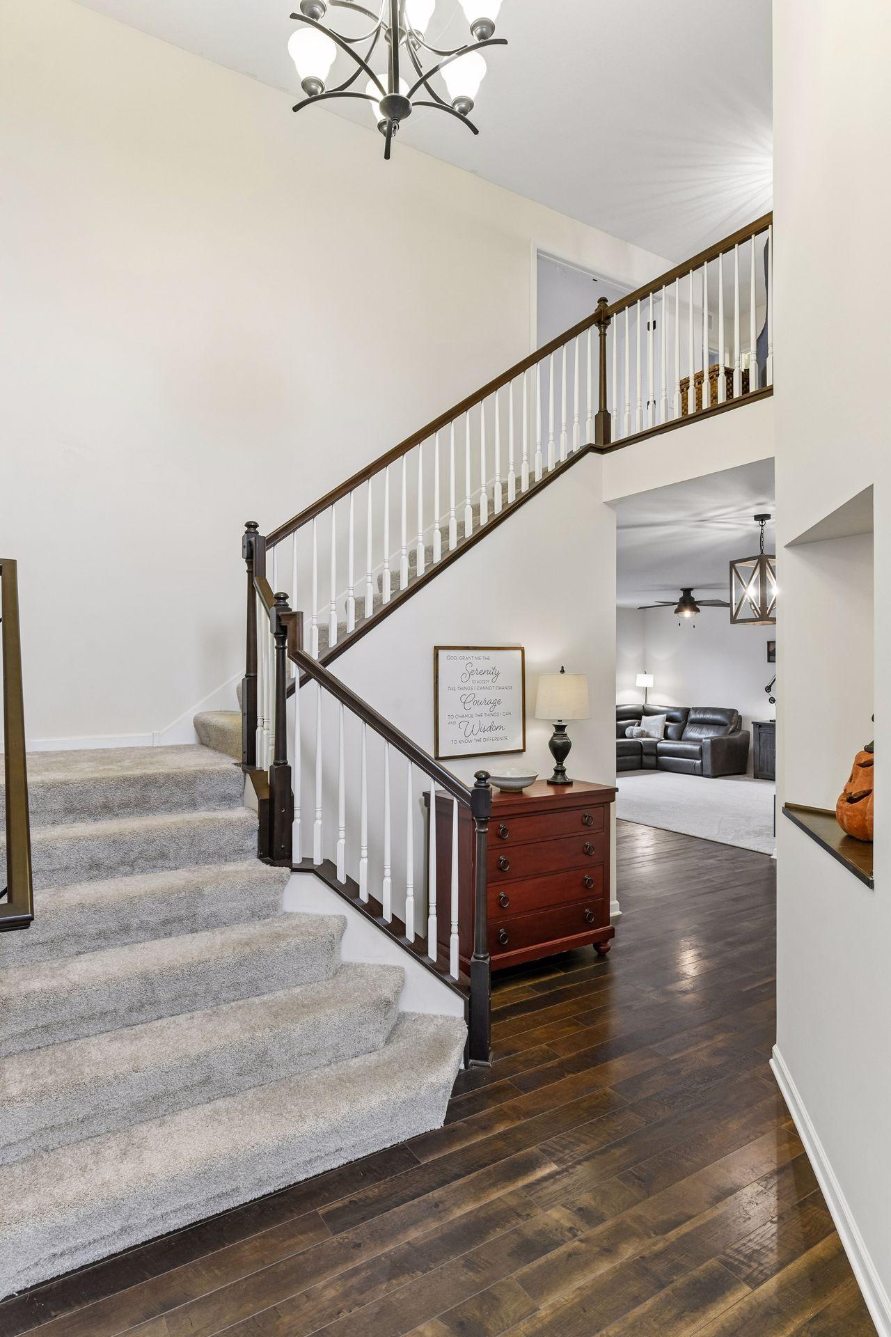 Make a grand first impression with this dramatic two-story foyer featuring soaring ceilings, rich flooring, and an elegant open staircase. Flooded with natural light, this welcoming entry sets the tone for the home's spacious and inviting design.