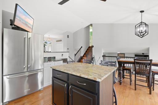 Panoramic view of kitchen, dining area, stairs leading to upstairs bedrooms.