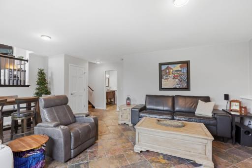 Pano view of lower level family room with custom tile flooring, light & bright sun filled room.