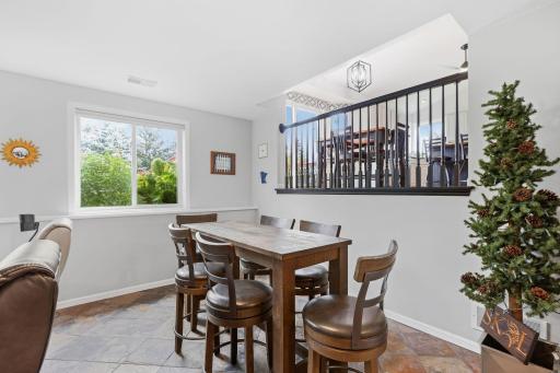 Dining space in lower level family room, view of open upstairs kitchen space.