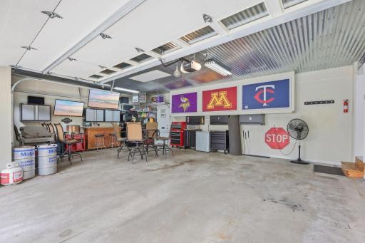 Amazing man cave style garage, heated & insulated, included flat panel TV's, refrigerator, included wall mounted storage/tool cabinets, work bench, custom tin decorative ceiling, pull down stairs for added storage.