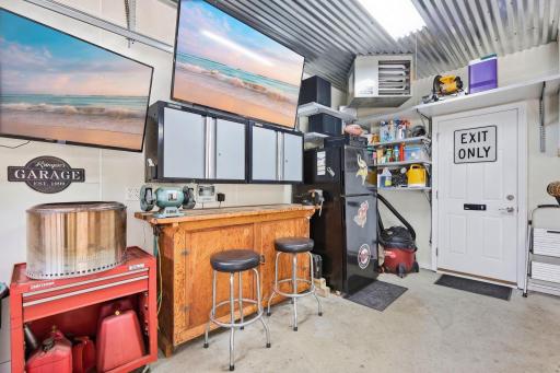Amazing man cave style garage, heated & insulated, included flat panel TV's, refrigerator, included wall mounted storage/tool cabinets, work bench, custom tin decorative ceiling, pull down stairs for added storage.