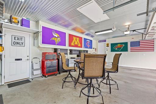 Amazing man cave style garage, heated & insulated, included flat panel TV's, refrigerator, included wall mounted storage/tool cabinets, work bench, custom tin decorative ceiling, pull down stairs for added storage.