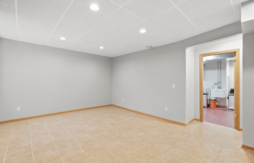 Basement level flex room with egress window, tile flooring, egress window.