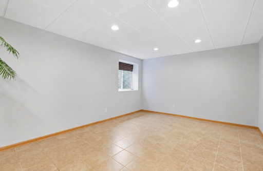 Basement level flex room with egress window, tile flooring, egress window.