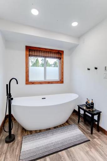 Beautifully remodeled bath features a freestanding soaking tub and modern finishes.