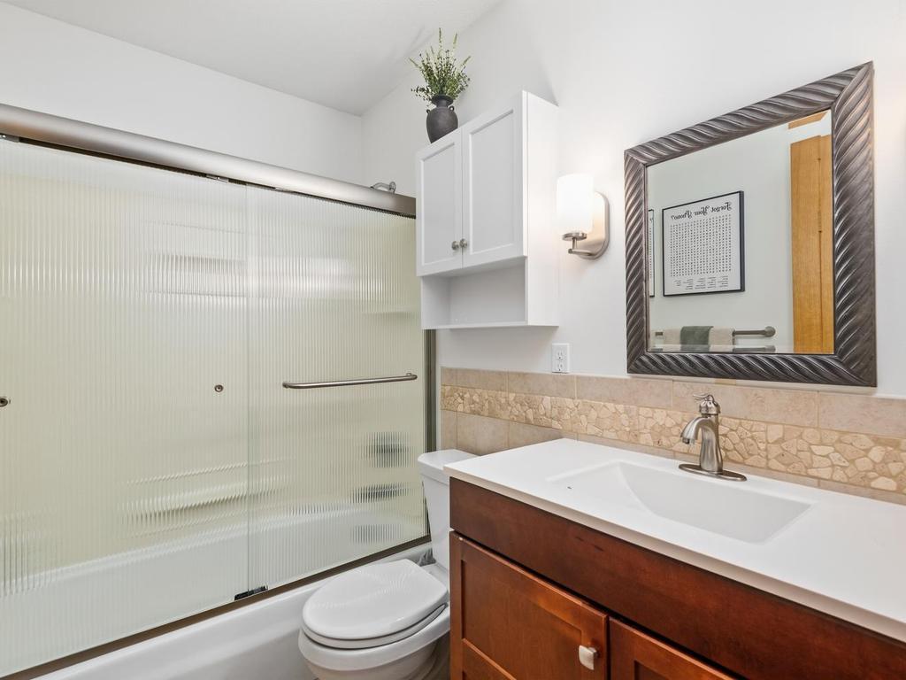 Main-level full bath with a tub and shower.