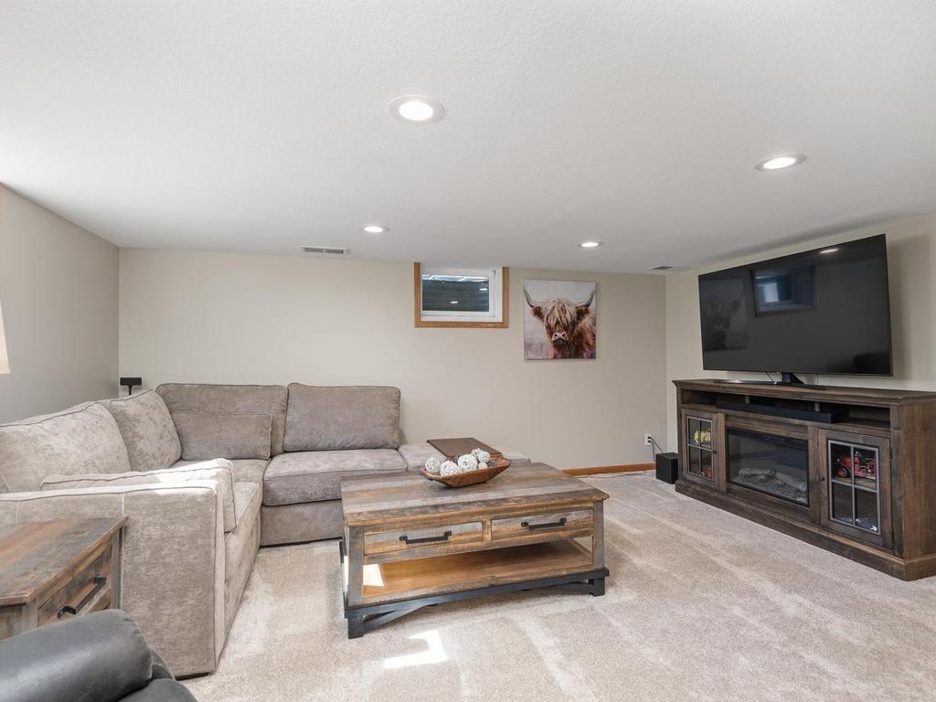 The spacious lower-level amusement room offers plenty of room for seating and entertainment.