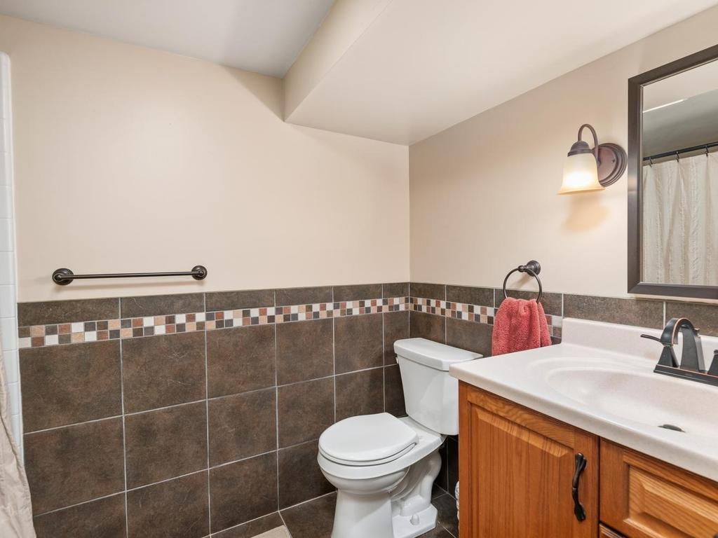 Lower-level ¾ bath with a tiled half wall.