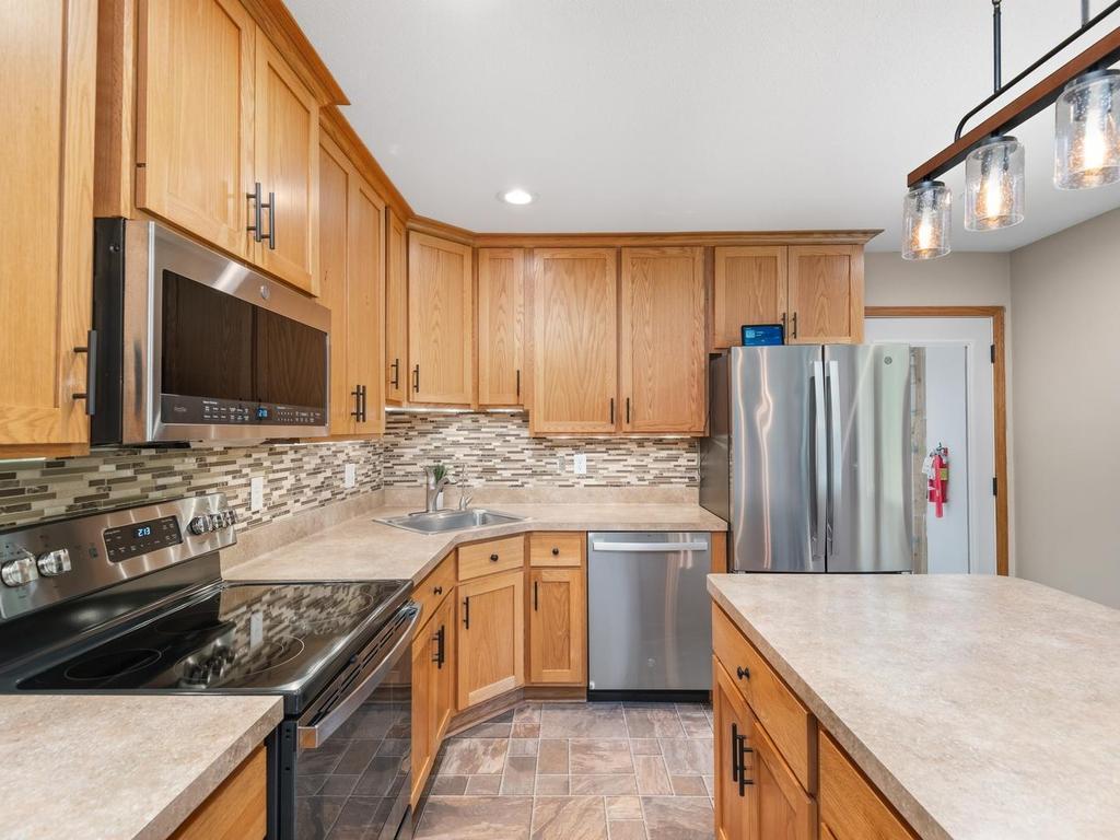 Another view of the kitchen’s cabinetry, tile backsplash, and generous counter space.
