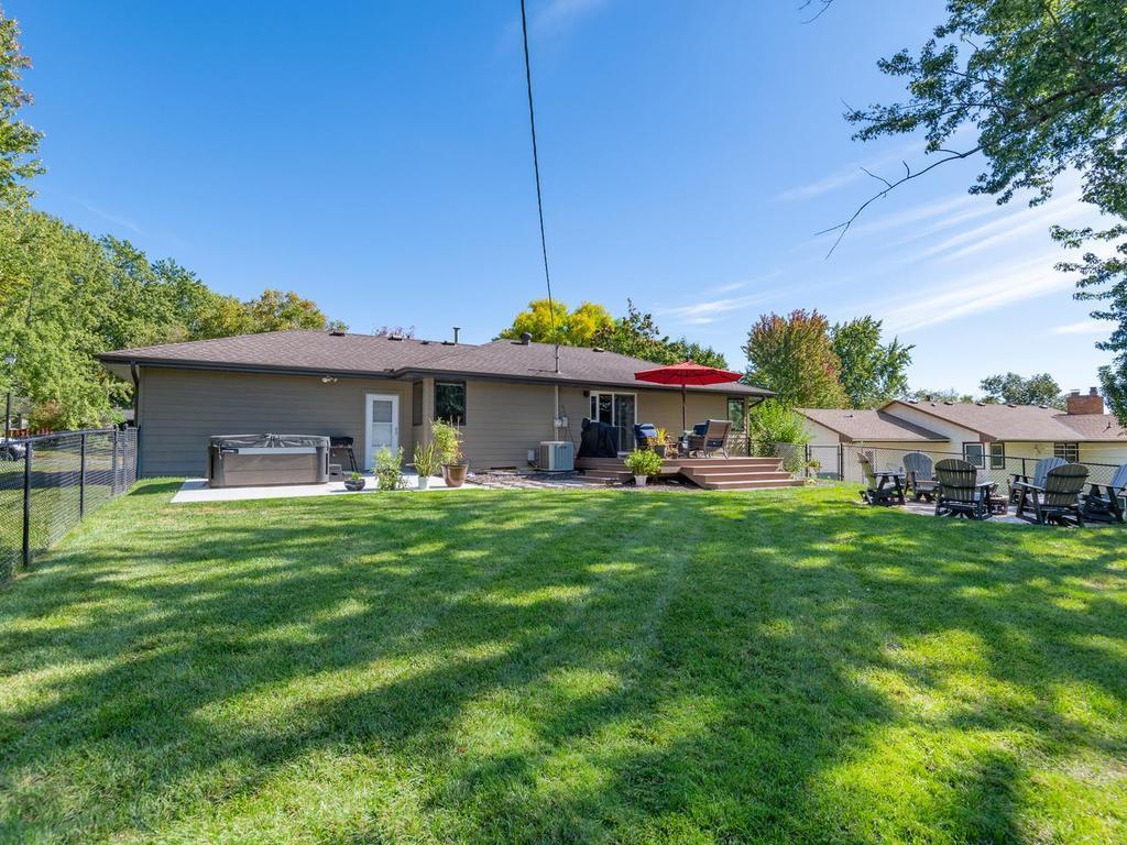 A wide view of the backyard shows the deck, patio, and fire pit area.