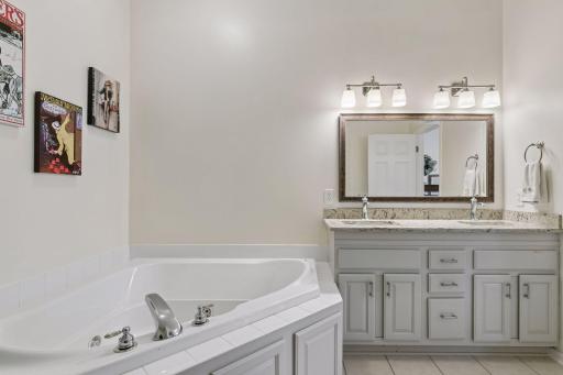 The primary features a large walk in closet and a full bath with separate soaking tub and glass-walled shower.