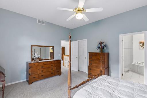 The primary features a large walk in closet and a full bath with separate soaking tub and glass-walled shower.