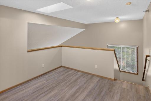 Versatile upper-level loft with new LVP flooring and abundant natural light.