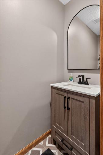 Updated main-level half bath with stylish vanity and modern fixtures.