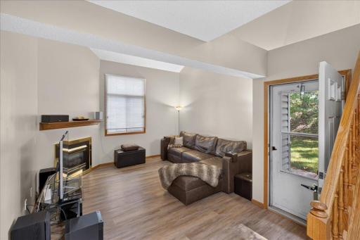 Spacious living room with new LVP flooring, fresh neutral paint, and cozy fireplace.