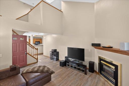 Open-concept living area showcases the dramatic ceiling height and upper-level loft overlook.