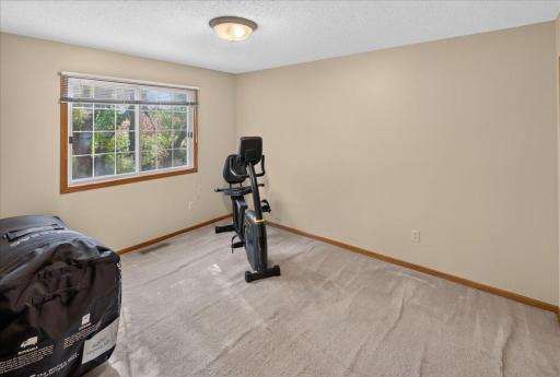 Spacious second bedroom with a large window overlooking the wooded surroundings.