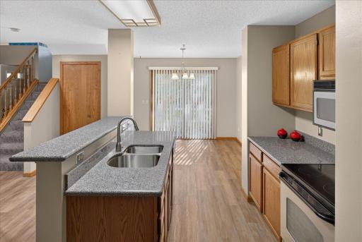Open kitchen and dining area with updated countertops, stainless-steel appliances and new LVP flooring.