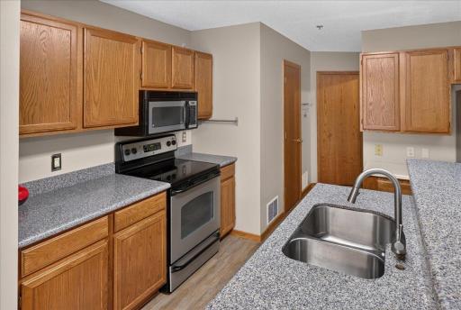Kitchen offers ample cabinetry, updated countertops, and stainless-steel appliances.