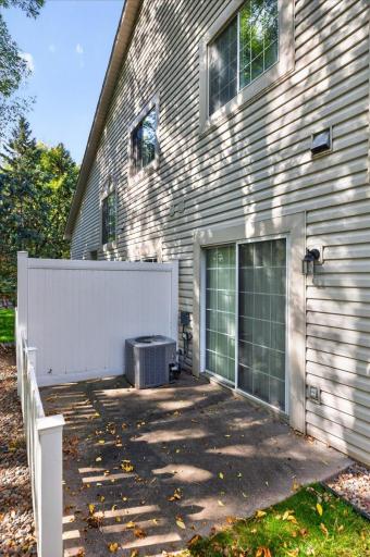 Private patio surrounded by mature trees, perfect for relaxing or outdoor dining.