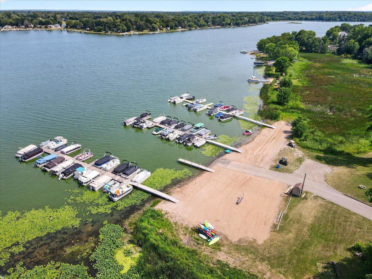 Impressive aerial view showcases the marina, docks, boat launch area, and lake frontage.