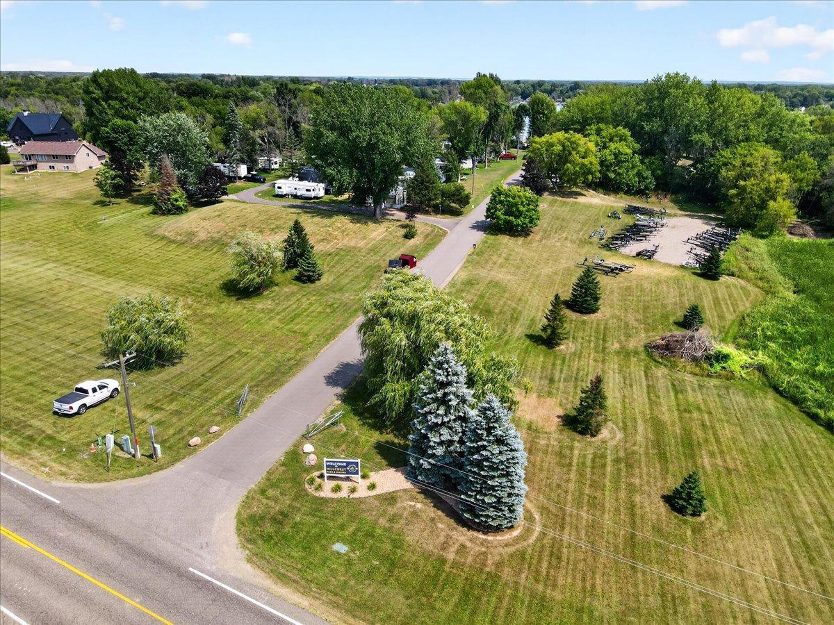 Aerial view highlights the spacious grounds, mature trees, and convenient property entrance.