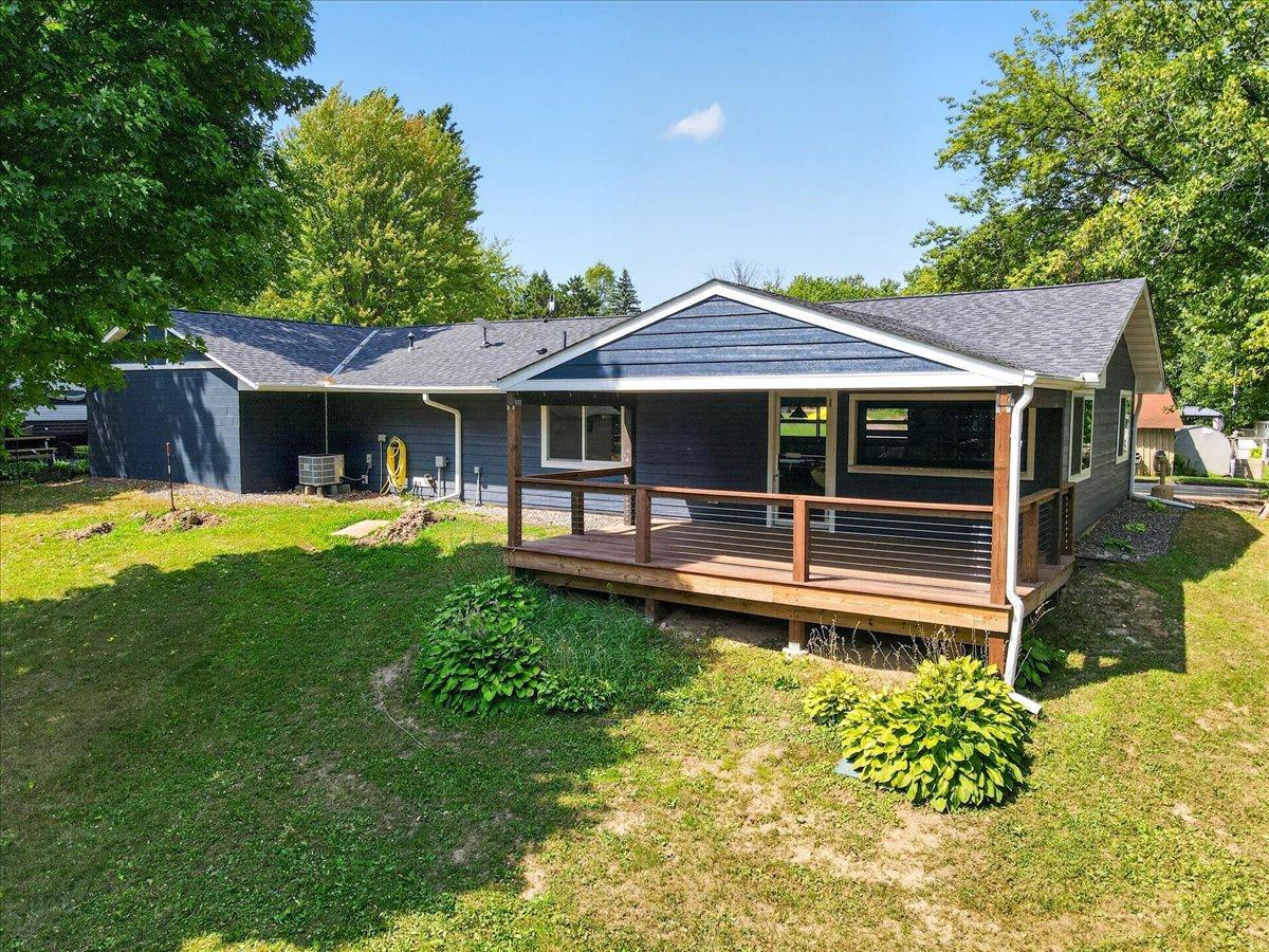 Additional view of the lodge showcases its covered deck and peaceful wooded surroundings.