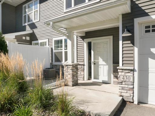 Concrete front porch area has a privacy fence between properties.