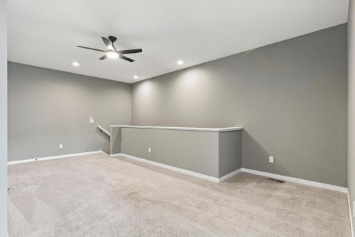 Loft area with ceiling fan and recessed lighting