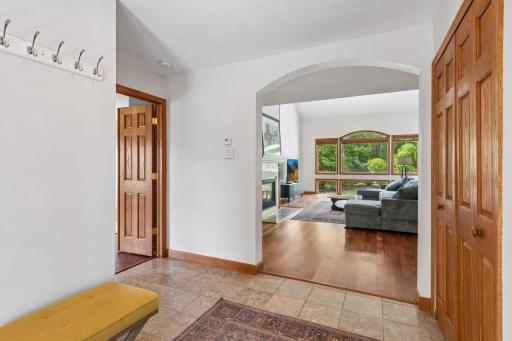 Straight ahead, the arched entry leads to the 2-story living / dining area, flanked by oversized windows. To the left is the primary suite.