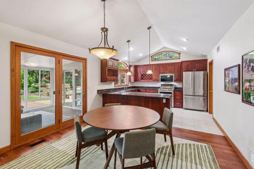 The open concept kitchen / dining area is great for parties and gatherings - the french doors lead to a screen porch between the home and the maintenance-free deck, which makes it easy to bring the party outdoors!