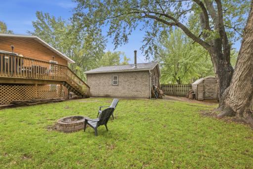 The back of the house and garage both feature log shiplap siding. A wood stove in the garage, added in 2014, creates a comfortable space for projects, hobbies, or relaxing.
