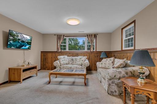The family room features carpet flooring while ceramic tile flooring runs through the lower-level hallway and walkway.