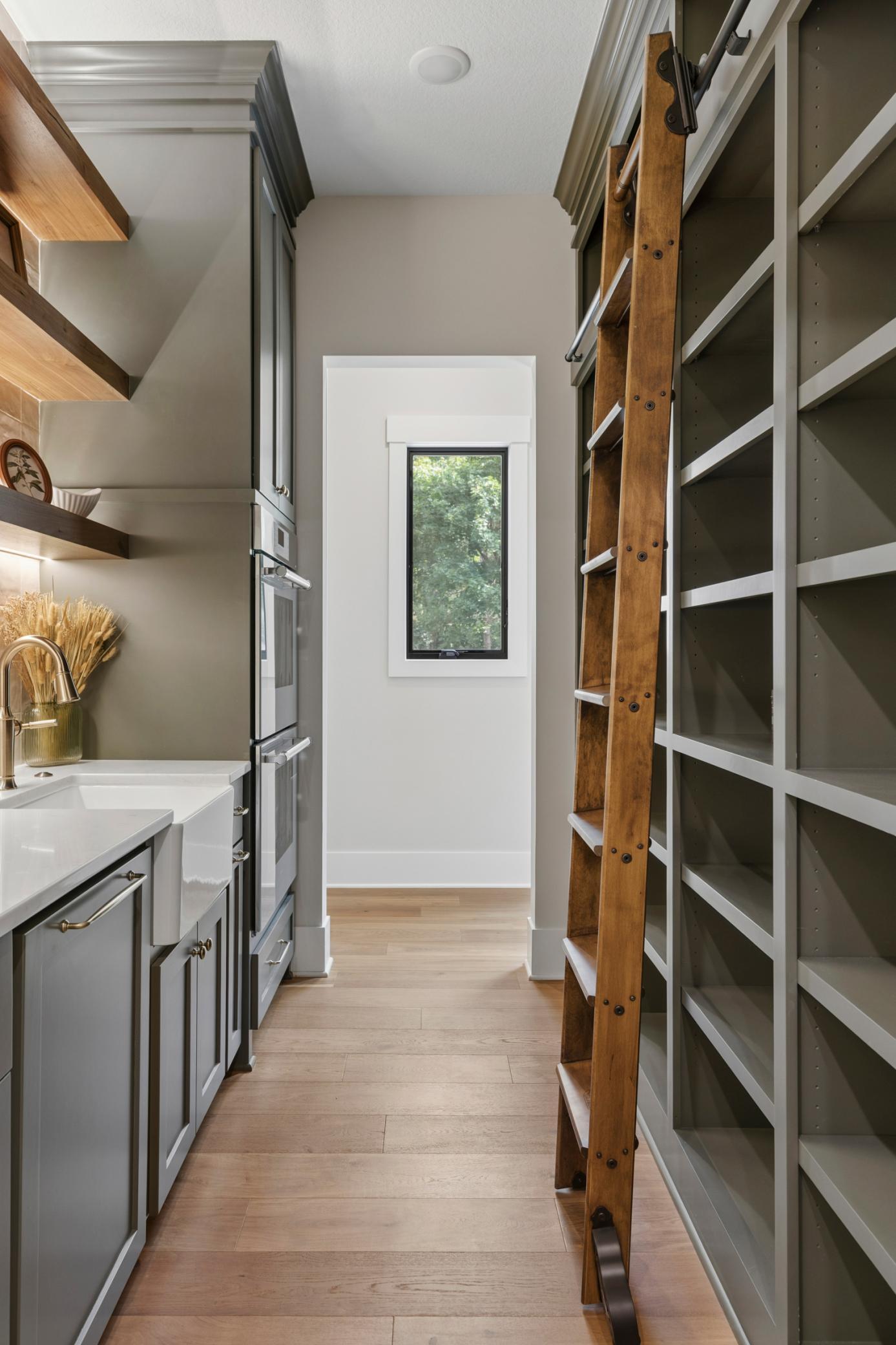 Pantry with double ovens & dishwasher with storage to ceiling & ceiling