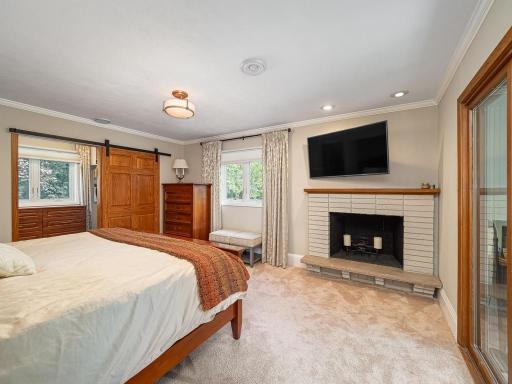 Wood fireplace in Owners Suite is original to home and used only for decorative purposes. The private sunroom to the right was updated with new windows, insulation and carpet in 2023. Great place to enjoy your morning coffee!