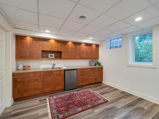 Wetbar/ Kitchenette with egress window. A microwave used to be located over the dual sink which also has a garbage disposal . Door to the updated 3/4 bath is to the left.