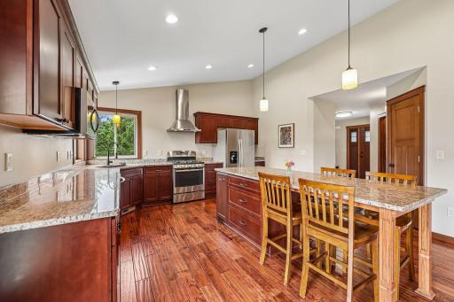 Kitchen with vaulted ceilings, large Granite Island, corner sink window, SS appliances, solid Birch wood flooring