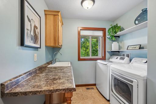 Main Floor laundry with built in cabinets and sink