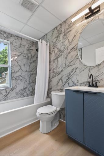 Upper level full bathroom 1 with new vanity, toilet and tile surround