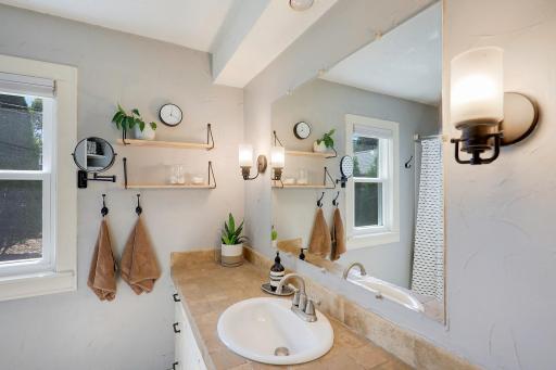 The full bath has a long vanity with storage cabinets.