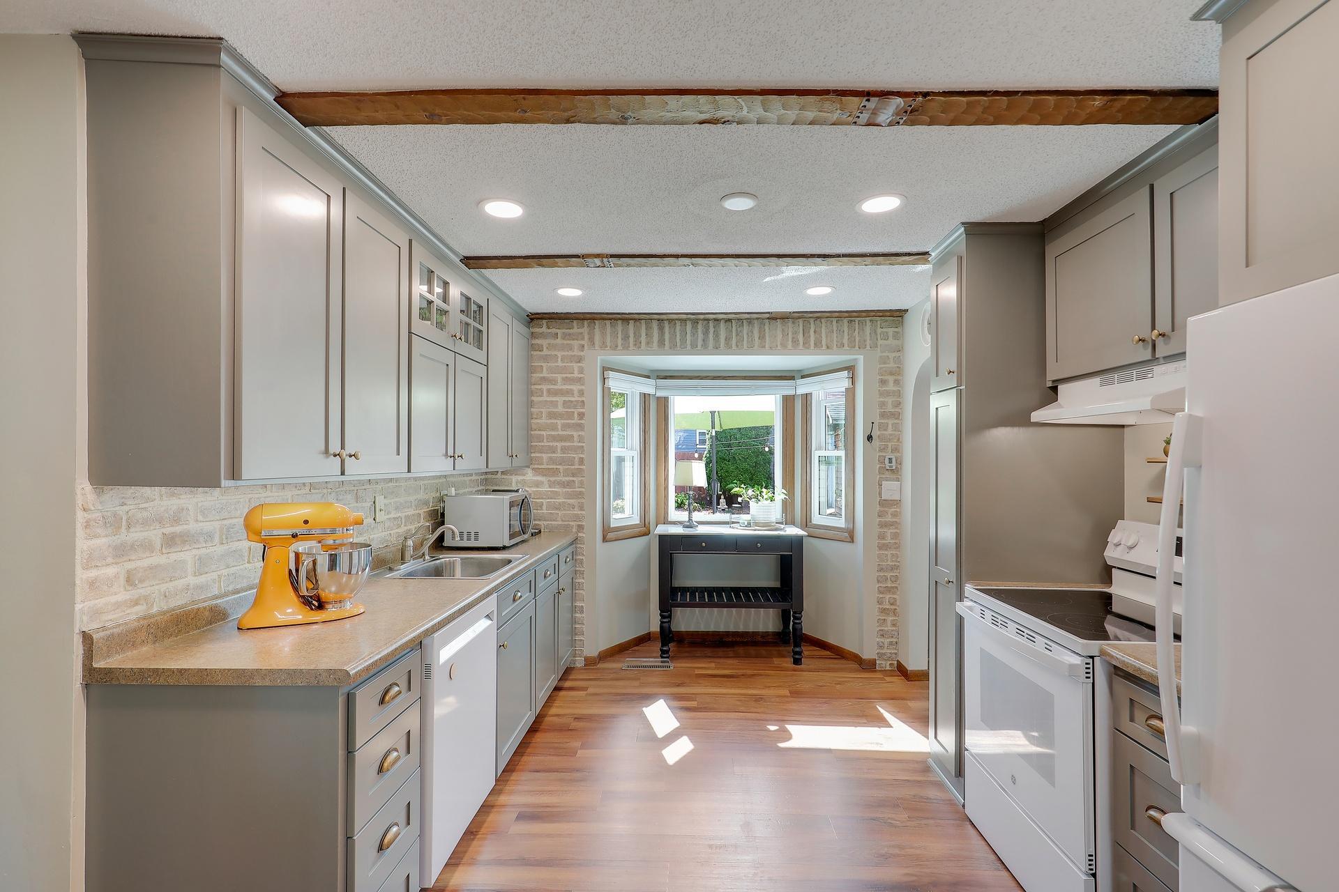 Lots of cabinets for storage and a bayed window for added charm.
